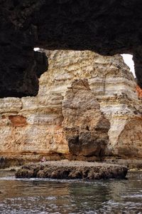 Rock formations by sea against sky