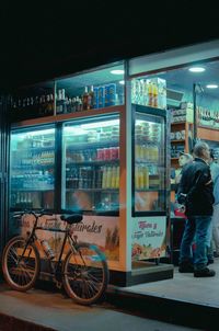Man standing by illuminated window in city