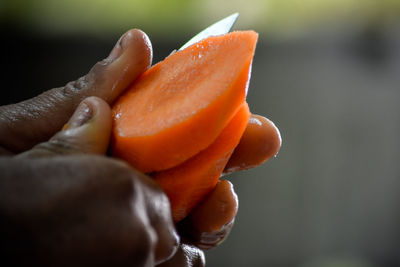 Cropped hands of person slicing carrot