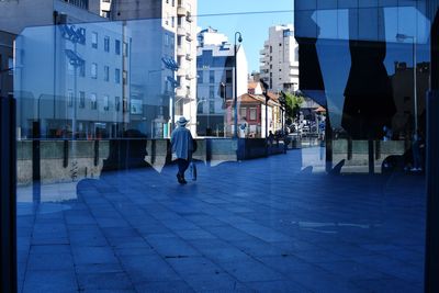 People walking on footpath amidst buildings in city