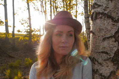 Close-up of woman in hat against tree