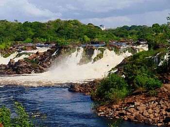Scenic view of waterfall against sky