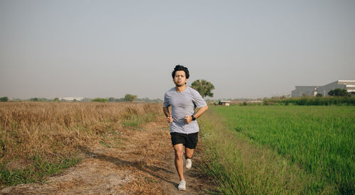 Athletic young asian man running jogging in the nature at morning, young men exercise in the morning