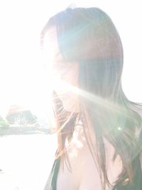 Portrait of young woman against bright sun