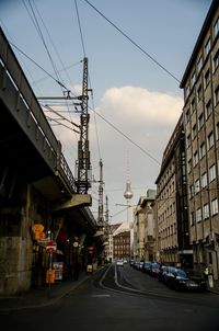 Cars on street in city against sky