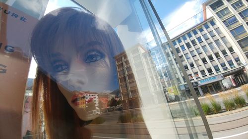 Close-up of young woman with reflection on window