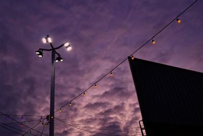 Low angle view of street lights against sky at sunset