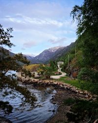 Scenic view of stream by trees against sky