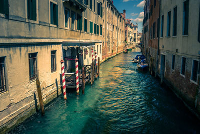 Boats in canal amidst buildings