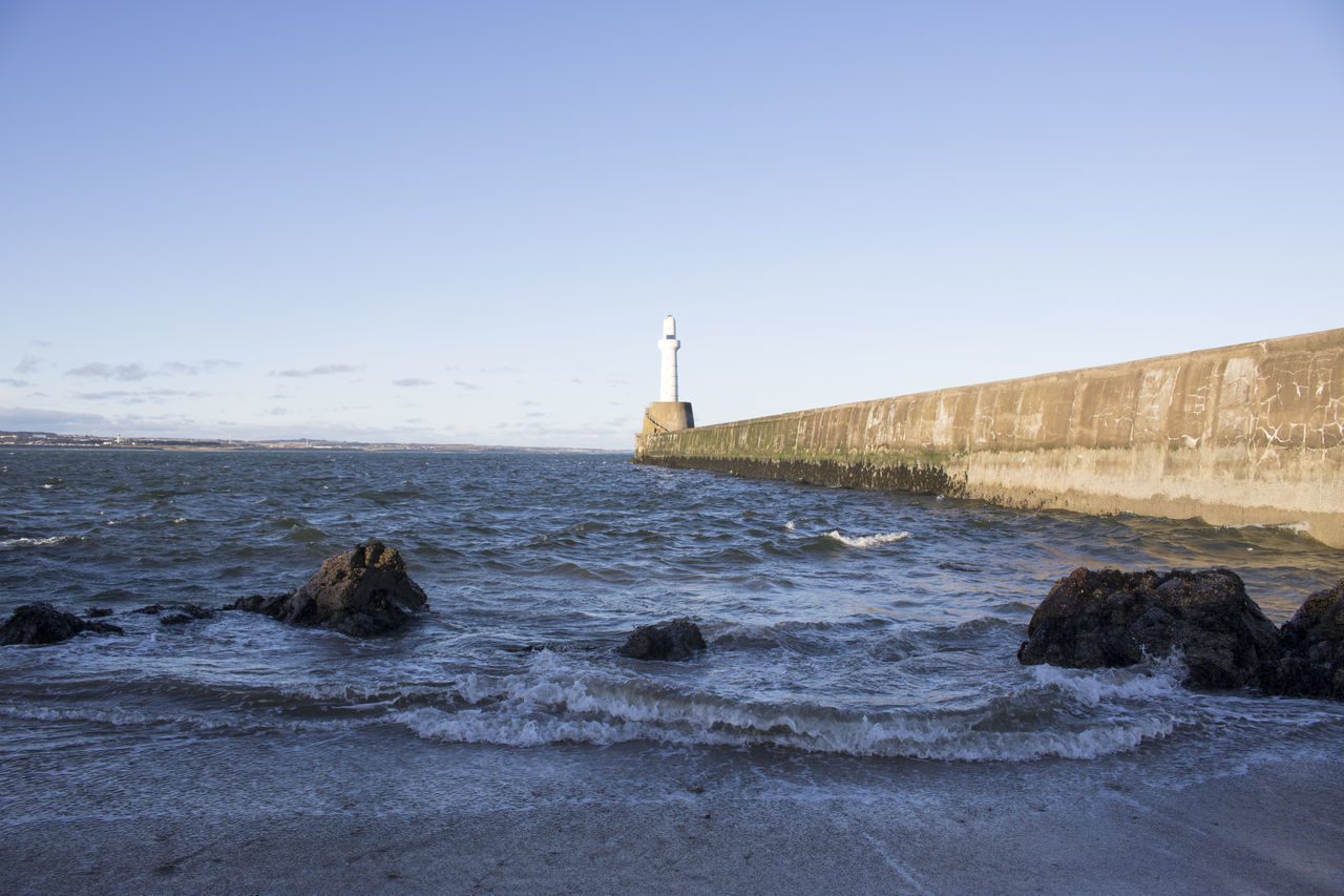 LIGHTHOUSE ON SEA AGAINST CLEAR SKY