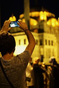 Cropped image of woman holding illuminated lamp