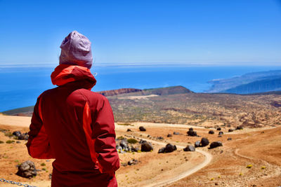 Rear view of man standing on rock