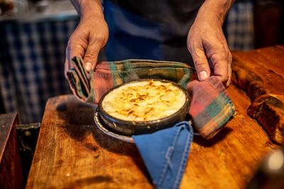 Midsection of chef holding food on table