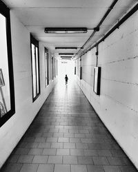 Rear view of people walking in corridor of building