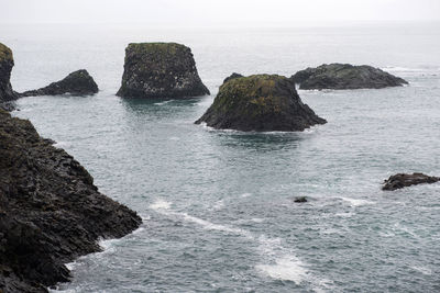 Rocks in sea against sky