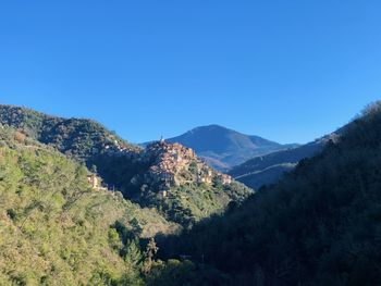 Scenic view of mountains against clear blue sky