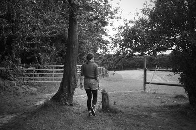 Full length of woman standing on tree trunk