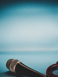 Close-up of coin-operated binoculars by sea against sky