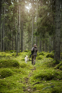 Woman with hunting dog in forest