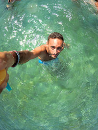 High angle view of young man swimming in sea