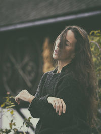 Woman in romantic pose between rustic houses, slovenia v