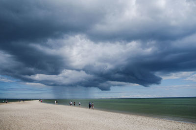 Scenic view of beach against cloudy sky