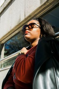 Low angle view of teenage girl wearing sunglasses while sitting in bus