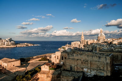 Panoramic view of sea and buildings against sky