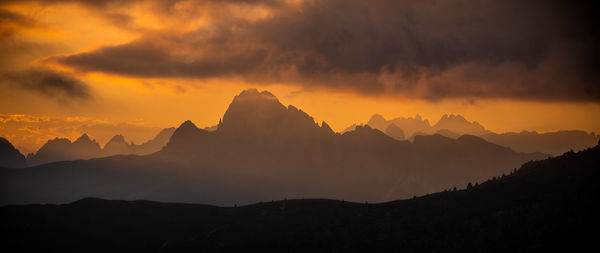 Scenic view of silhouette mountains against dramatic sky