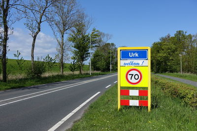 Information sign by road against sky