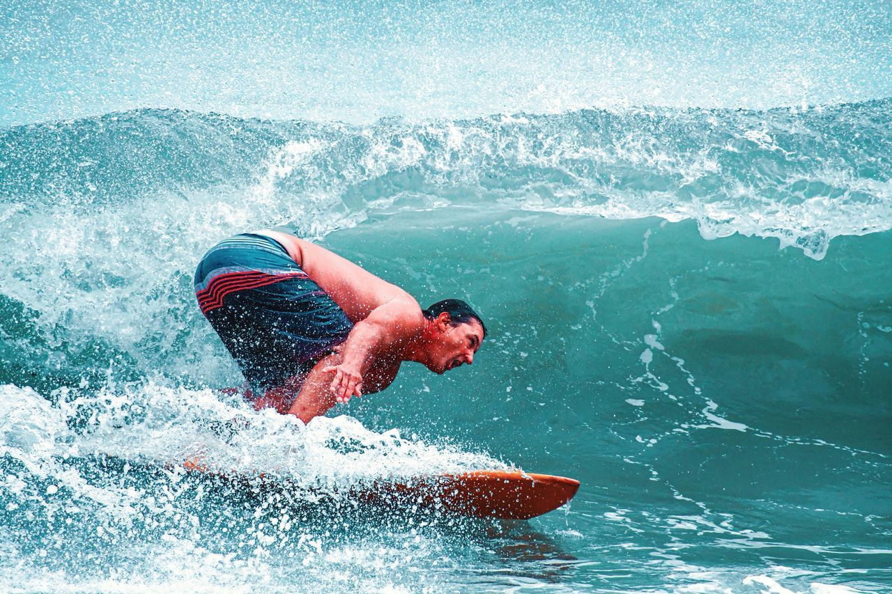MAN SURFING ON SEA WAVES SPLASHING
