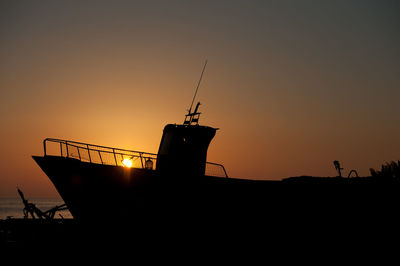 Silhouette of ship against clear sky at sunset