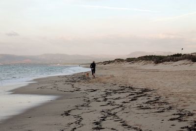 Man standing on beach against sky