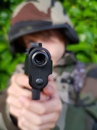 Close-up of army soldier aiming with gun