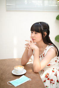 Portrait of woman with coffee cup on table