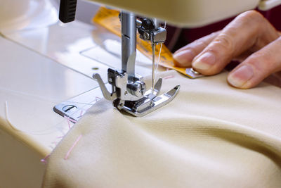 Midsection of woman working on sewing machine