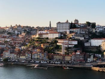 River amidst buildings in city against clear sky