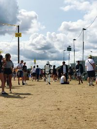 Group of people playing soccer on land against sky