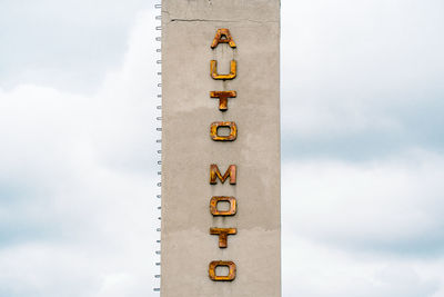 Auto moto rusty letters on concrete tower