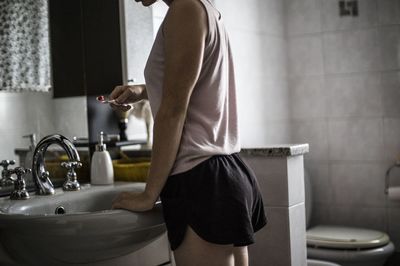 Side view of senior woman standing in bathroom