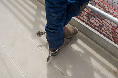 Low section of man standing on metal