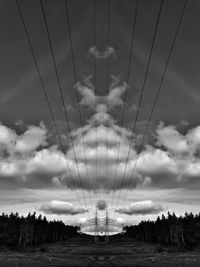 Low angle view of electricity pylon on field against sky