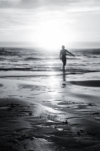 Silhouette man on beach during sunny day