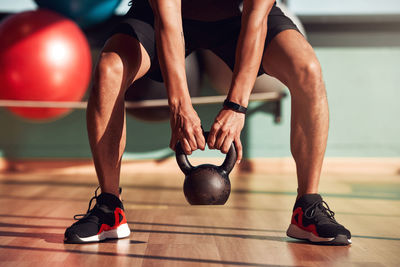 Low section of man tying shoelace