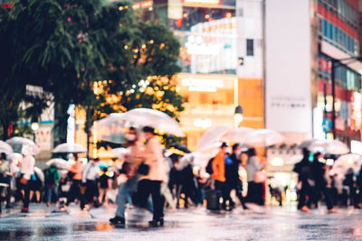 People walking on wet street in rainy season