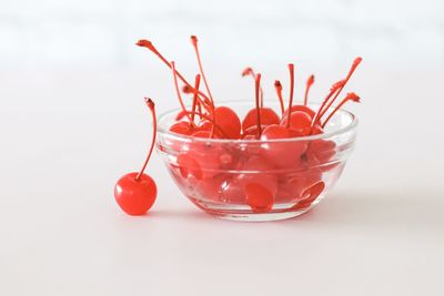 Close-up of red berries in glass over white background