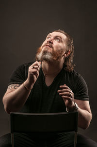 Young man looking away over black background