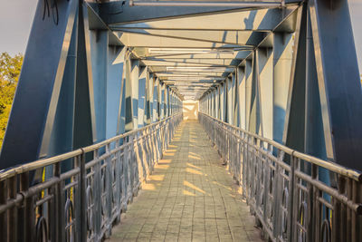 Narrow footbridge along railings