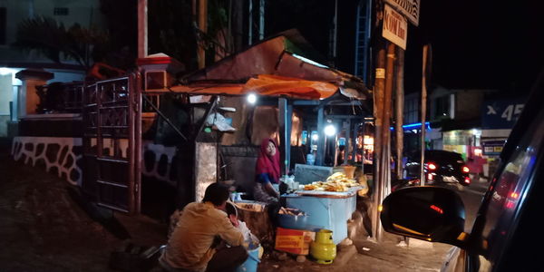 People at market stall at night