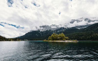 Scenic view of lake by mountains against sky